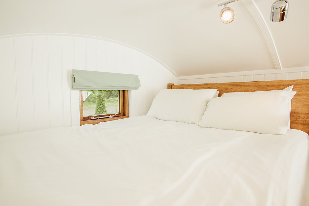 Double bed with bedding in shepherd's hut