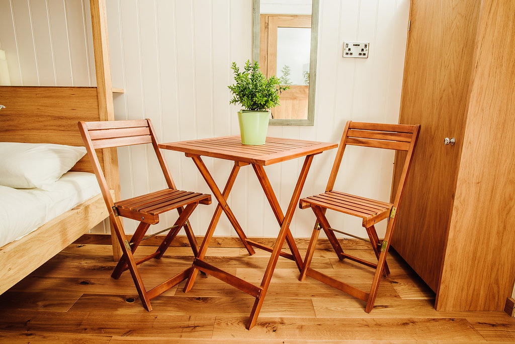 Bed, table and chairs in shepherd's hut