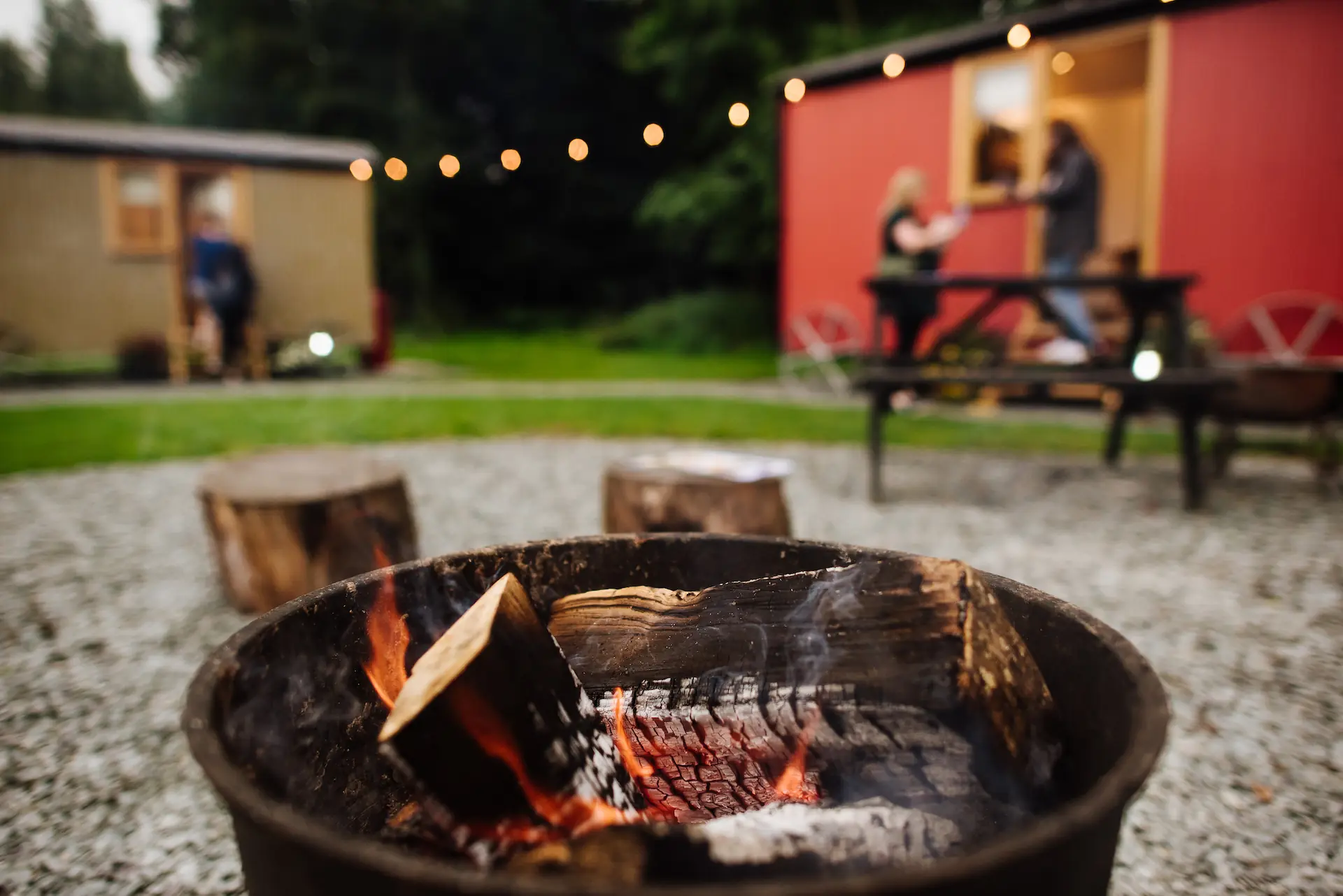 Two shepherd's huts surrounding a firepit