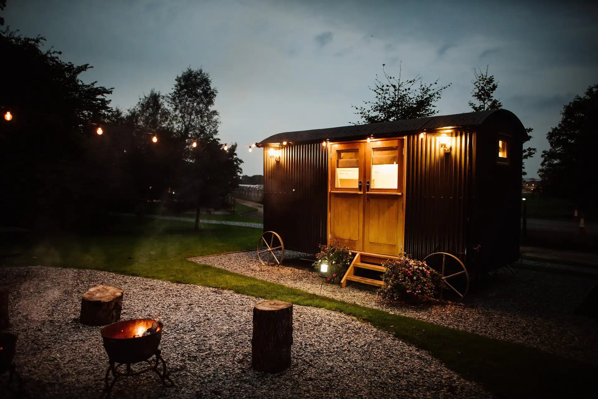 Shepherd's hut at dusk with festoon lights