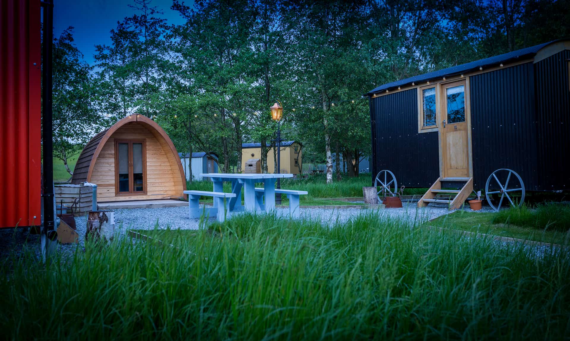 Selection of shepherd's huts at dusk, set in grass lawns