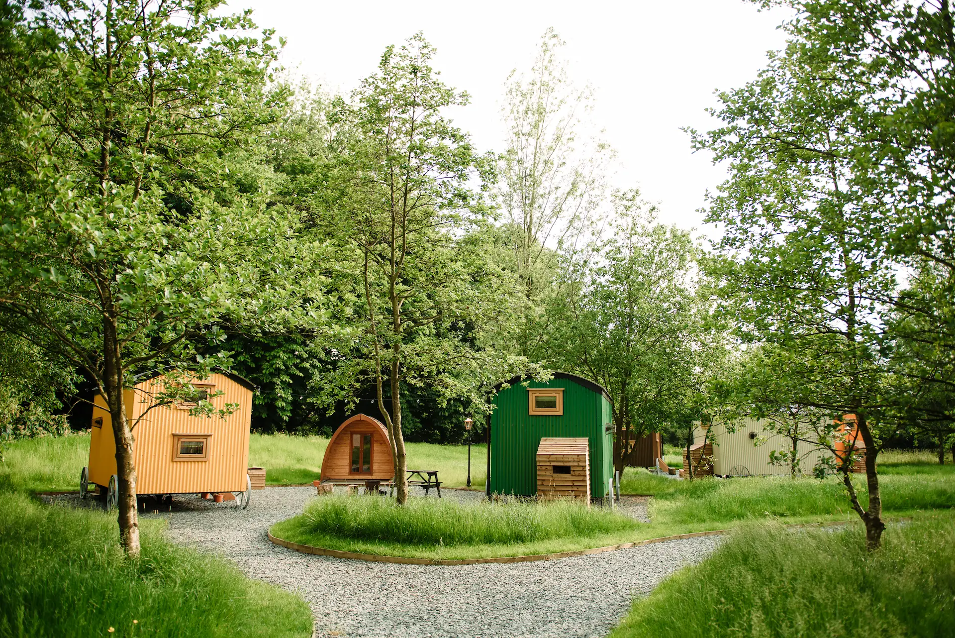 Selection of shepherd's huts and gravel pathways between, interspersed with grass