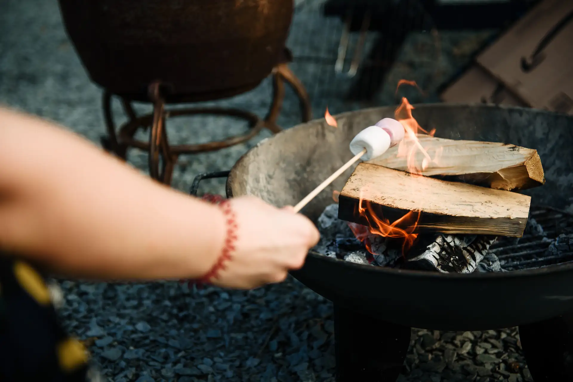 Person toasting marshmallows over a firepit